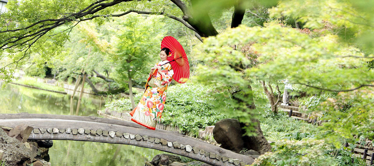 肥後細川庭園にかかる橋の上で和傘を持ち微笑む新婦
