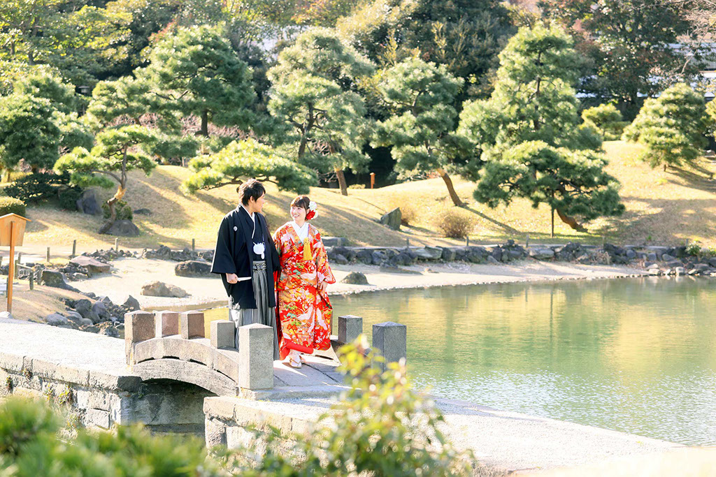 芝離宮の橋を楽しそうにわたる新郎新婦