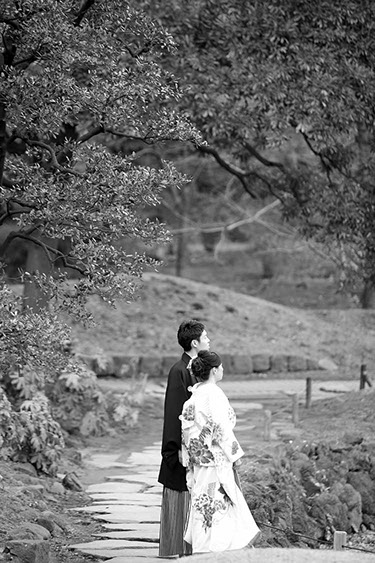 芝離宮庭園に立つ和装姿の新郎新婦のモノクロ写真
