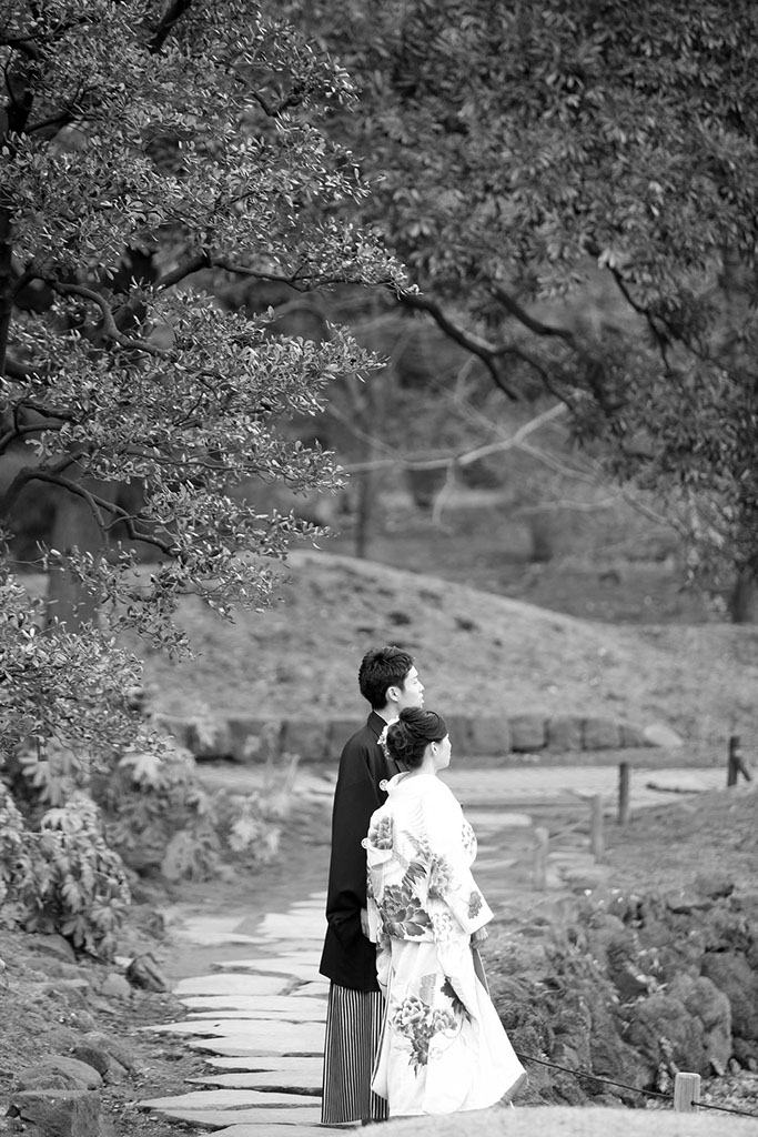 芝離宮庭園に立つ和装姿の新郎新婦のモノクロ写真