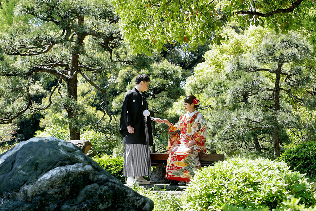 清澄庭園の松の前で手を取り合う和装新郎新婦