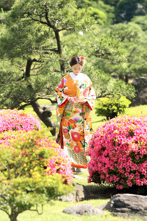 ツツジの花の前で微笑む新婦