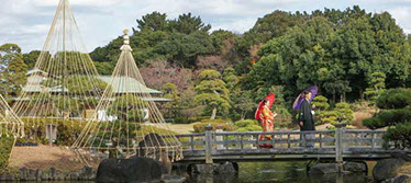 枯山水の飛び石を手を繋いで歩く新郎新婦