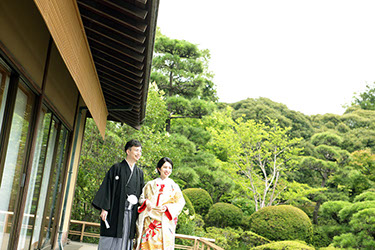 池を見つめ微笑む新郎新婦