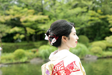 池を背景に微笑む新婦