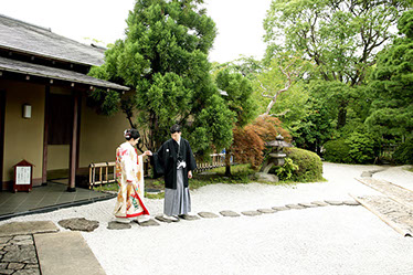 枯山水の庭を手を引いて歩く新郎新婦