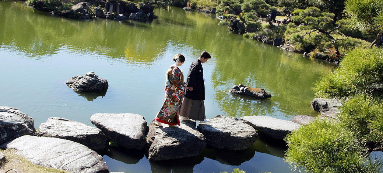枯山水の庭を手を引いて歩く新郎新婦