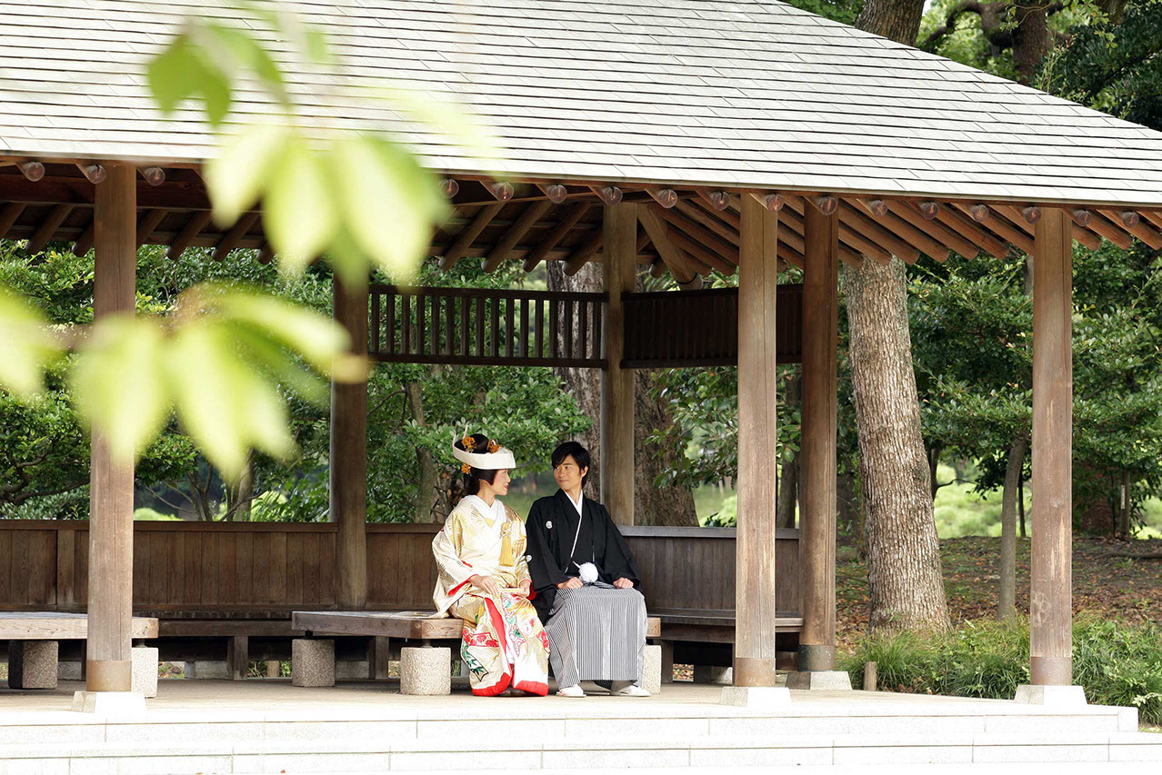 清澄庭園の東屋に腰掛けて見つめ合う新郎新婦