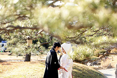 待つ話の中でおでこを合わせる和装姿の新郎新婦