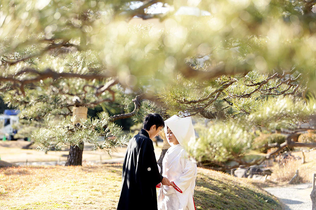 待つ話の中でおでこを合わせる和装姿の新郎新婦